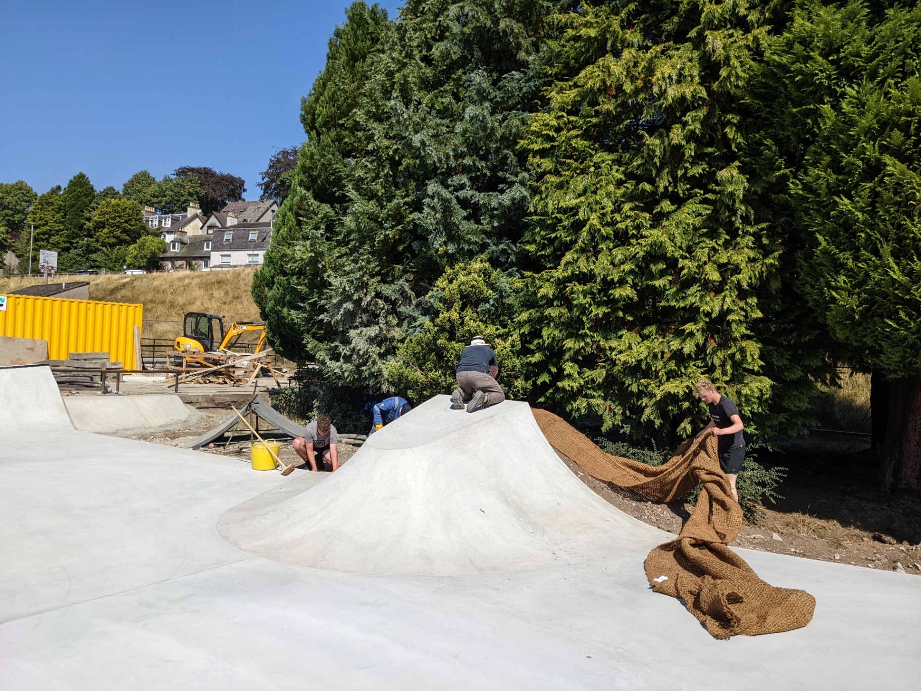 Volunteers working on a finished mound under blue summer skies